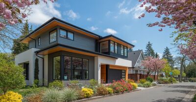 Modern new construction home in a Portland Oregon suburb with cherry blossom trees and a well-landscaped front yard