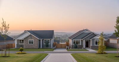 Calm front view of new single family construction homes in suburban Portland under soft golden morning light
