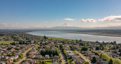 Aerial view of Vancouver Washington neighborhoods with Mount Hood visible in the distance and the Columbia River separating Washington from Oregon