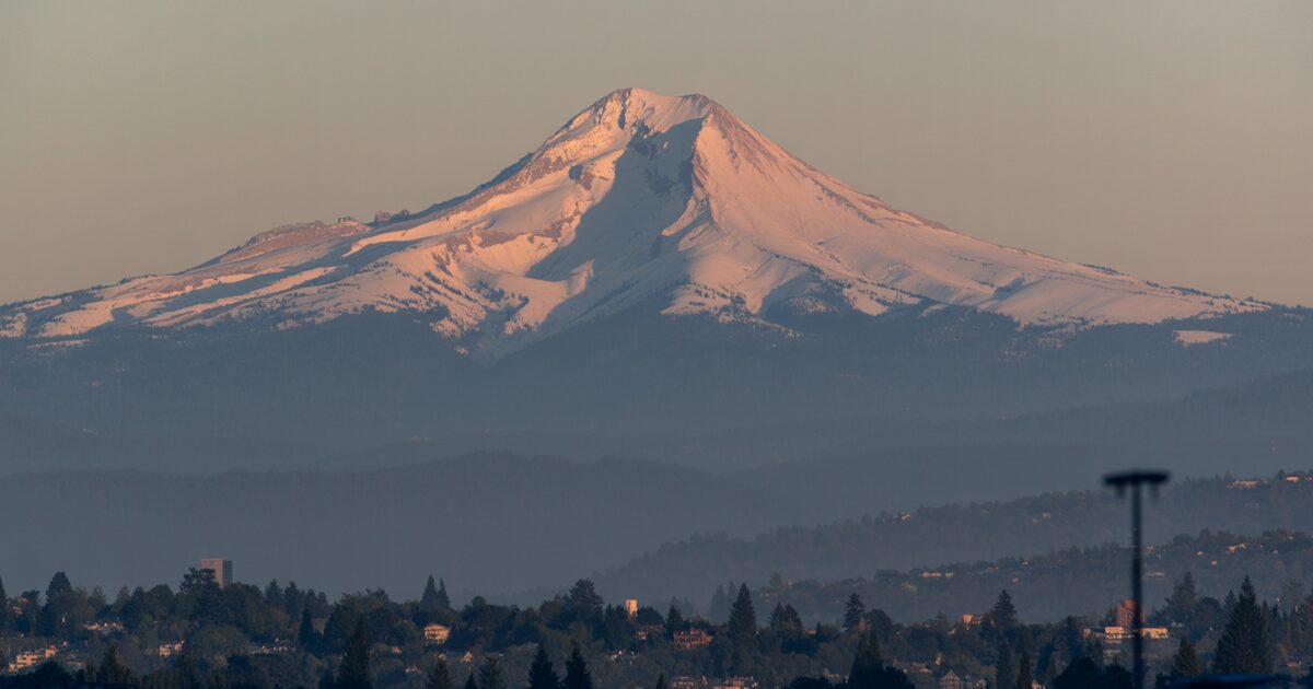 Mount Hood rising above the Portland metro area in hazy late summer evening light